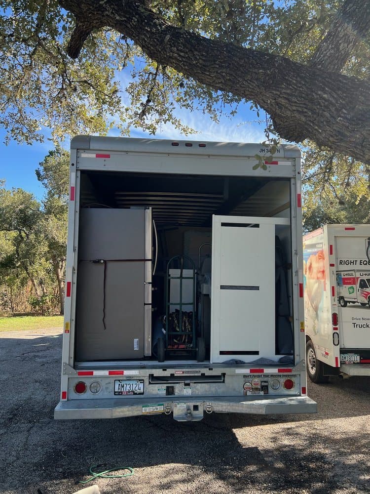 A refrigerator and appliances loaded upright in a box truck