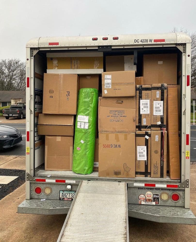 The inside of a Nu2U Moving box truck, fully loaded with wrapped and labeled boxes