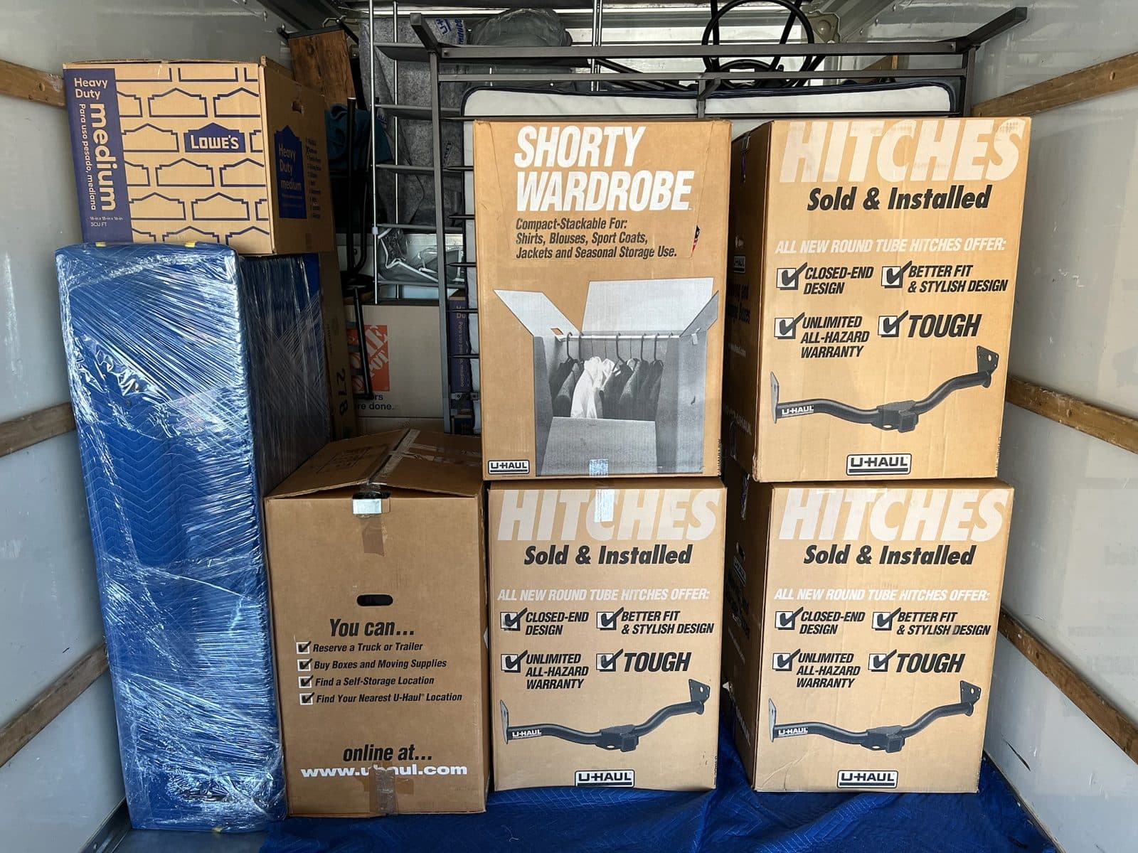 Boxes and a blanket-wrapped mattress packed tight inside a moving truck