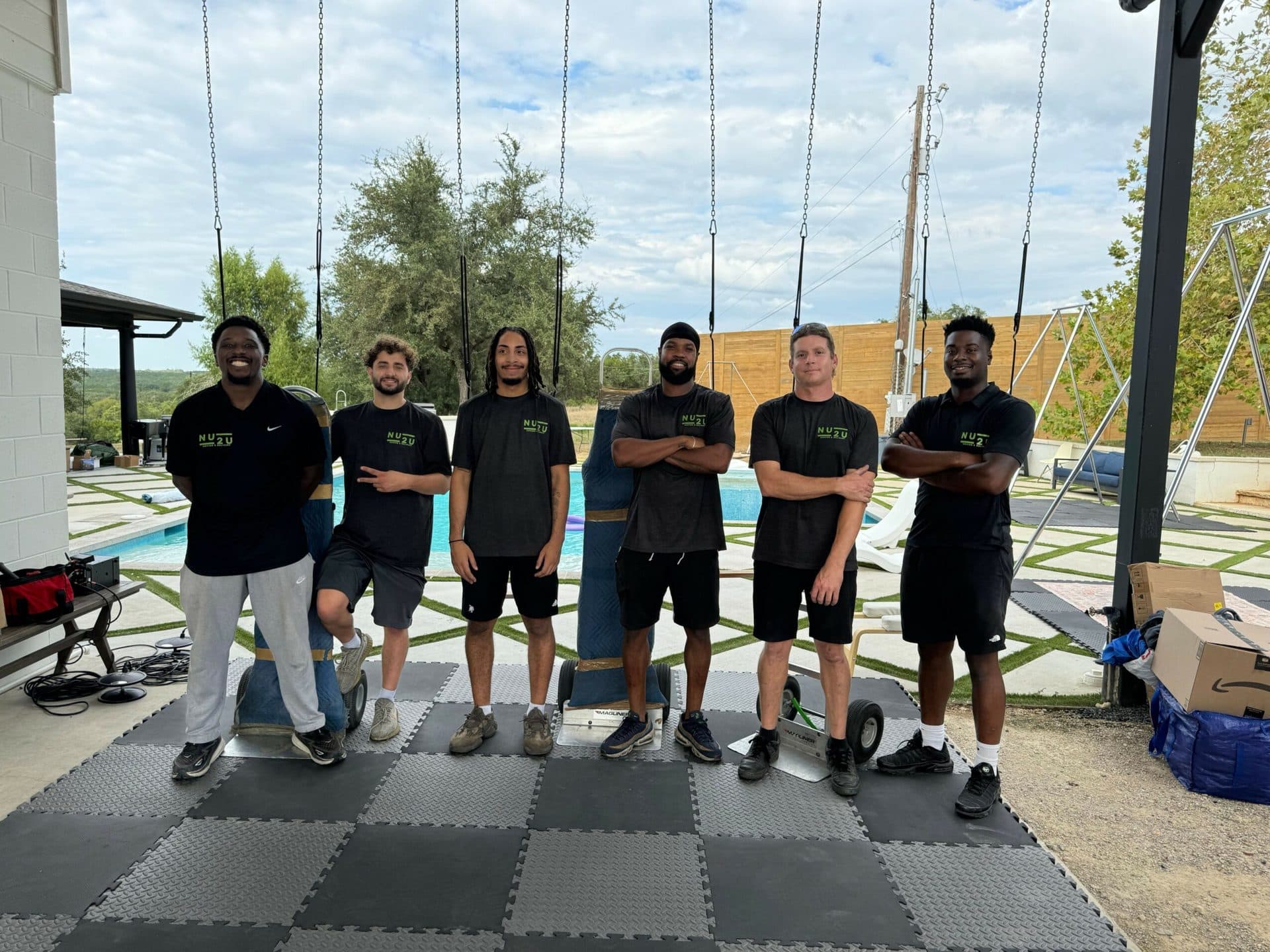 The Nu2U Moving crew in matching black shirts, smiling for the camera