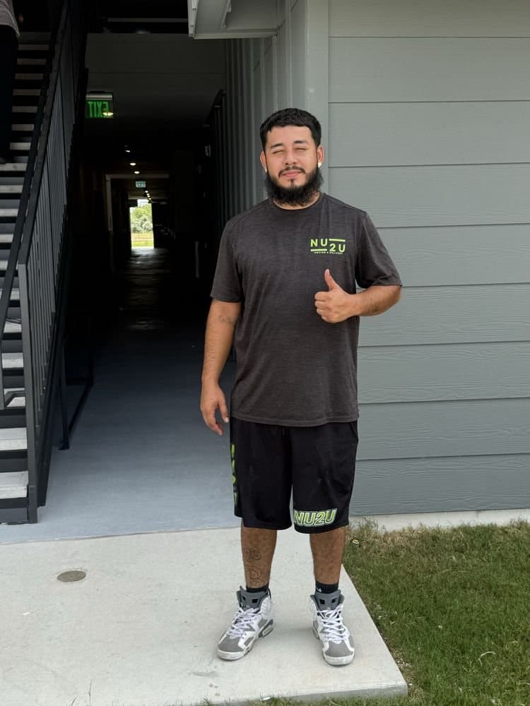 A Nu2U mover in a branded shirt giving a thumbs up