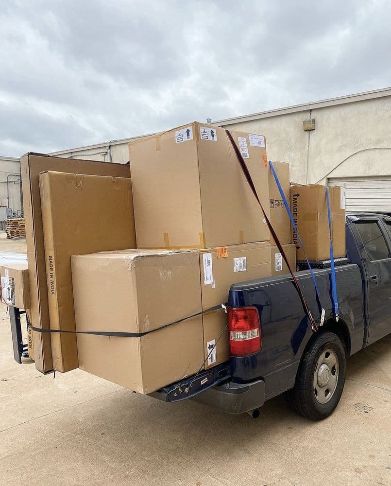 A pickup truck loaded and strapped down with moving boxes