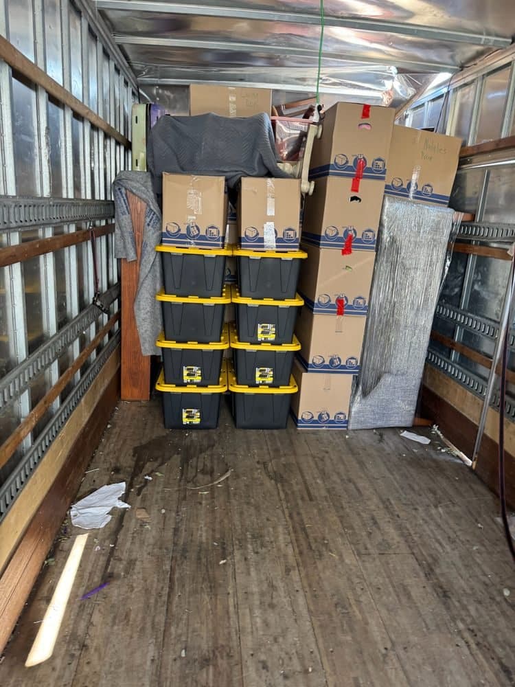 Storage bins and boxes stacked neatly inside a moving truck