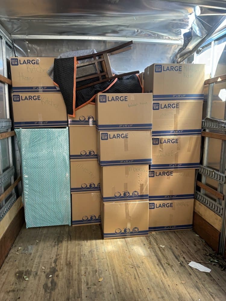 A tight wall of large moving boxes stacked inside a truck